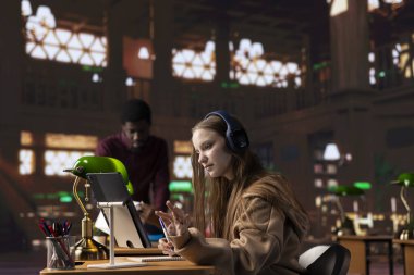 Dizüstü bilgisayarında eğitici bir belgesel dinleyen ve notlar alan genç bir kız, üniversite kütüphanesinin sessizliğinde ders çalışmak için geleneksel olmayan bir yol kullanıyor. Öğrenci akademik veri topluyor.