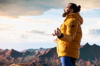 Huzurlu bir kâşif, stres atmak için meditasyon yapıyor. Dağın tepesinde rahatlık ve denge için dinleniyor. Genç gezgin, dikkat çekmek için meditasyon yapıyor..