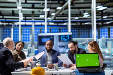 Fabrika hissedarları verileri analiz ediyor, sistem sağlık ölçümlerini model dizüstü bilgisayarla inceliyor. Ofisteki endüstriyel fabrika yatırımcıları krom anahtar not defteri kullanarak sorun çözme sorunları yaşıyorlar