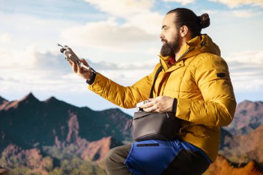 İçerik üreticisi temiz havanın tadını çıkarıyor ve insansız hava aracıyla çekim yapıyor, Mountain Range Valley hava sahasında profesyonel video kaydediyor. Nüfuzlu kişi son seyahat vlog 'unu kaydediyor.