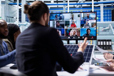 Photovoltaics fabrika yönetimi ekibi üretim ekipmanları hakkında konuşmak için video görüşmesi yapıyor. İş adamları yeşil enerji yatırımlarında işbirliği yaparak telekonferans yatırımcılarıyla sohbet ediyorlar