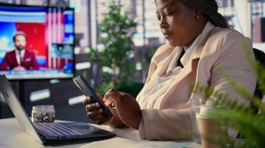 Siyahi girişimci personeliyle güncellemeleri veya iş fikirlerini tartışıyor, internet bağlantısıyla ilgili kısa mesajlar yoluyla proje içgörüsünü paylaşıyor. Başarılı hedef odaklı siyah CEO. Kamera B.