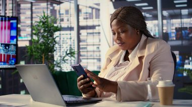 Afrikalı Amerikalı şirket müdürü molasında mesajlar yolluyor. Organizasyon projesinin geliştirilmesinden memnun. Kadın CEO, ağdaki çalışanlarıyla görüşlerini paylaşıyor. Kamera B.