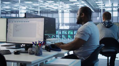 Mühendis kod yazıyor ve sunucu odasında farklı iş yükleri için hesaplama kaynakları sağlıyor. Veri merkezi ana bilgisayarlarını inceleyen adam bilgisayar, kamera B kullanıyor.