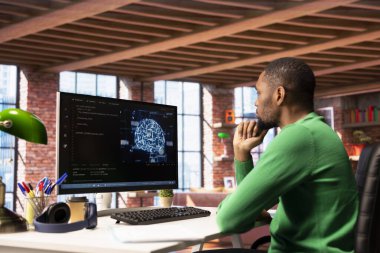 Bilgisayarlı bilgisayar ağlarında bilgisayar kodları yazıp, yapay zeka nöral ağlarının bakımını yapıyorum. Klavyede yazı yazan, yapay zeka sistemlerini kontrol eden Afro-Amerikan teknik destek uzmanı