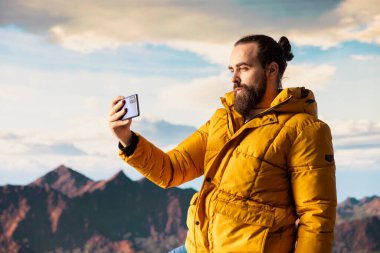 Yürüyüşçü maceracı dağın tepesindeki nefes kesici manzarayı yakalar, uzak bir dağ sırasına bakar ve vahşi doğanın güzelliğini kucaklar. Mucizeleri keşfetmenin sevinci.