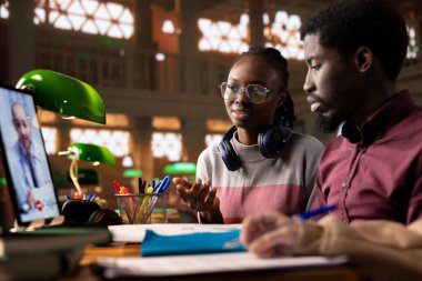 Çeşitli öğrenci takımları bir doktorla video görüşmesi yapıyor, tıbbi konuları ve yöntemleri öğreniyorlar. Tıp öğrencileri bir üniversite kütüphanesinde uzaktan eğitim için teletıp araçları kullanıyorlar.