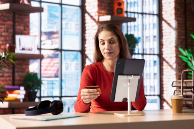 Sorumlu yetişkin faturalarını ödüyor, vergilerini tabletine yazıyor, ödeme detaylarını internete giriyor ve para transferini onaylıyor. Çevrimiçi bankacılık ve merkez ofisten finans.