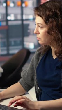 Ajans ofisinde video üretim endüstrisinde çalışan dikey video kadın uzman editör, renk derecelendirme yapıyor ve çift monitörlerde bir montaj yaratıyor. Multimedya teknoloji araçları ile yaratıcı süreç