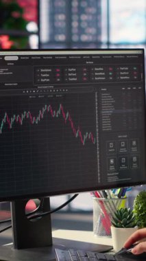 Dikey Video Borsası yatırımcısı, finansal arayüzdeki dijital grafikleri ve şamdan örneklerini izliyor. PC ticaret istatistikleri gösteriyor, veri güdümlü yatırım kararları veriyor ve riskleri yönetiyor