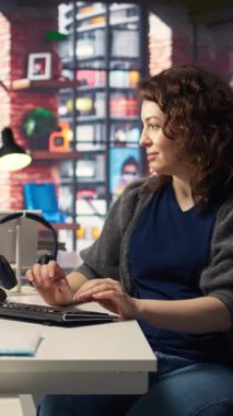 Dikey Video Kadın Sistemi Yöneticisi yapay zeka sistemlerinde bakım yapıyor, ofis masasında oturuyor. Kız, sibernetik ve makine öğrenme algoritmalarında yazılım geliştiricisi olarak çalışıyor. Kamera A.