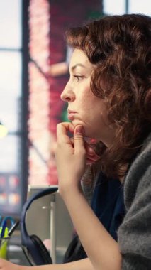 Vertical Video Financial yatırımcısı PC üzerinde çalışıyor. Borsa eğilimlerini analiz ediyor. Dijital arayüz fiyat dalgalanmalarını, şamdan çizelgelerini gösteriyor. Likidite istatistikleri gelecekteki ticaretin stratejisine yardımcı olur