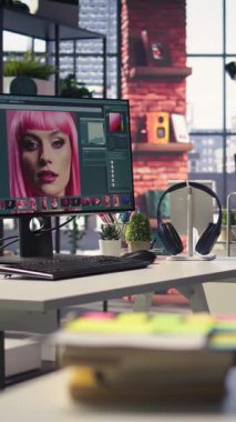 Yapay zeka ve rötuş yazılımına sahip bir fotoğraf editörü için dikey video modern yaratıcı ofis, gelişmiş tasarım programı çalışan bir bilgisayarın olduğu boş bir masayı gösteriyor. Sanatsal dijital ortam ayarları.