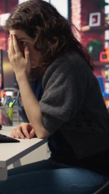 Dikey Video Günü tüccarı, mali kayıplara bakarak, bilgisayar üzerinden hisse senedi fiyat eğilimlerini analiz ederek endişeli ve stresli hissediyor. Öfkeli kadın hisselerini kaybediyor ve piyasa çöküşü ve ticaret kararlarıyla uğraşıyor.