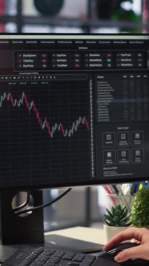 Dikey Video İşkadını borsa görüntüleme araçlarını kullanarak finansal grafikler üzerinde çalışıyor. Dijital ticaret platformu yatırım planlaması için ekonomik veriler, önx analizleri ve fiyat eğilimleri sunar