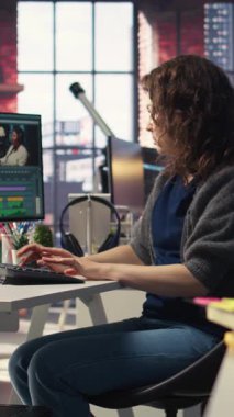 Vertical Video Focused editörü kadın ajans ofisinde, dijital medyada yaratıcı yazılımda video montajı üzerinde çalışıyor. Çekimleri düzenlemek ve içerik yaratmak için çift monitör kullanan film yapımcısı, prodüksiyon sonrası