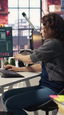 Dikey Video Kadın Editör Tasarımcısı, yaratıcı bir ofiste çift monitörlü masaüstü, bilgisayar kurulumunda fotoğrafları rötuşlar. Fotoğraf düzenleme üzerine odaklanmış dijital medya profesyoneli için ideal çalışma alanı. Kamera A.