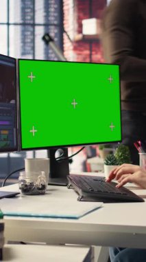 Dikey Video Kadın video oluşturucu, zaman çizgisi düzenleme ve video üretimini yönetmek için profesyonel teknoloji araçları ve kurgu yazılımı kullanarak, ajans ofisinde kroma anahtarının yanında bir multimedya projesini düzenler