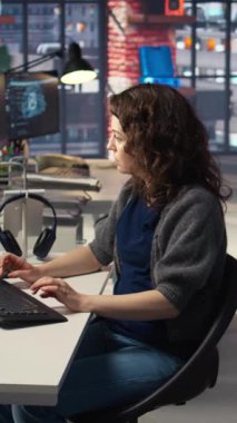 Ajans ofisinde video üretim endüstrisinde çalışan dikey video kadın uzman editör, renk derecelendirme yapıyor ve çift monitörlerde bir montaj yaratıyor. Multimedya teknoloji araçları ile yaratıcı süreç