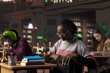 Afrikalı Amerikalı öğrenci kütüphanedeki eğitim araştırma koleksiyonunu inceliyor, lisans diplomasını almak için sınavlarına çalışıyor. Genç öğrenci burs için savaşıyor..