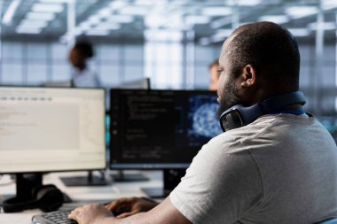 Bilgisayar bilimcisi veri merkezi performansını optimize etmek için yapay zeka teknolojisi kullanıyor. Afrika kökenli Amerikan bilişim uzmanı sunucu çiftliğinde potansiyel sorunları doğru tahmin etmek için yapay zeka teknolojisini kullanıyor