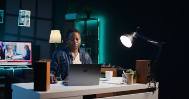 Evden çalışan bir tele-işçi, dizüstü bilgisayarda klavye kullanıyor, belge yazıyor. Uzaktan çalışan klavyede tuşlara basar, iş ortaklarına e-posta gönderir, kamera B kapatır