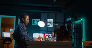 Ana ofiste, programlama dili kodu yazmak için dizüstü bilgisayar kullanarak serbest çalışan bir yönetici. Uygulama yapmak için dizüstü bilgisayarı kullanarak evden çalışan yazılım teknisyeni, kamera B