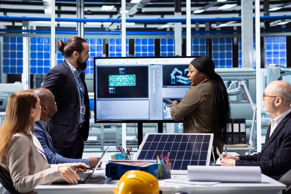 Fabrika yöneticileri güneş paneli teknolojisi ve otomasyon stratejilerini tartışıyor, gelişmiş sanayi tesislerindeki sürdürülebilir üretim süreçlerini geliştirmek için verileri analiz ediyorlar.