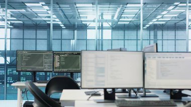 Boş veri merkezinin çalışma alanındaki bilgisayar ekranlarında kod çalıştırılıyor, sorun çözmede kullanılıyor. Masaüstünde çalışan betiği kapat PC monitörleri sunucu odasındaki ana bilgisayar sistemlerini güncelliyor