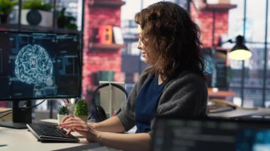 Yapay zeka sistemlerinde bakım yapan kadın sistem yöneticisi, ofis masasında oturuyor. Kız, sibernetik ve makine öğrenme algoritmalarında yazılım geliştiricisi olarak çalışıyor. Kamera B.