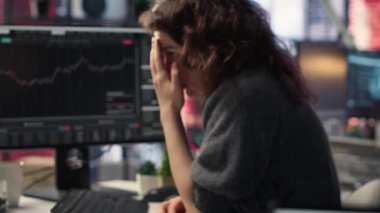 Hüsrana uğramış girişimci çift monitörlerde borsa büyümesini izliyor, eğilimleri ve likiditesi analiz ediyor. Ticaret arayüzü, bilgilendirilmiş alım-satım kararlarını, pazar çöküşünü sağlar. Kamera B.