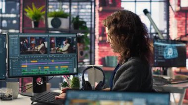Genç kadın video editörü yaratıcı ajanslarda çift monitörlerle çalışıyor, video görüntülerini düzenliyor ve yaratıcı süreç için renk sınıflandırması yapıyor. İçerik yaratmak için prodüksiyon gönderin. Kamera B.