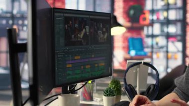 Odaklanmış editör kadın ajans ofisinde, dijital medyada yaratıcı yazılımda video montajı üzerinde çalışıyor. Film yapımcısı çekimleri düzenlemek ve içerik yaratmak için çift monitör kullanıyor. Kamera B.