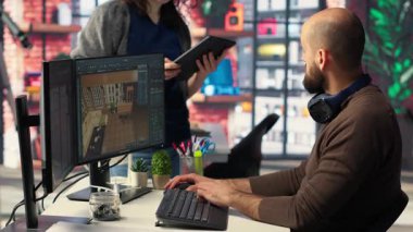 Ofisteki işçiler, sanal ev planlaması için kullanıcı arayüzü sağlayan bir evin içini tasarlamak için CAD yazılımı kullanıyorlar. Geliştiriciler takımı mimari düzen ve düzenlemeler yaratıyor. Kamera B.