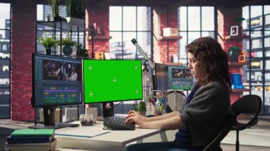 Yeşil ekranın yanında bir film montajı yapan kadın kameraman, çift taraflı monitör kurulumu ve düzenleme yazılımı ile birden fazla iş yapıyor. Sinema endüstrisi için prodüksiyon işlerini bitiriyorum. Kamera A.