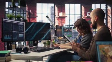 Analistlerden oluşan bir ekip, iş istatistiklerini izlemek için analitik araçlar kullanarak gösterge panelindeki sunum çizelgelerini ve verileri inceliyor. İnsanlar performans ölçümlerini ve diyagramlarını analiz eder. Kamera A.