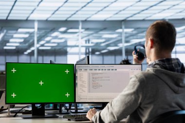 Bilgi işlem uzmanı yeşil ekran PC kullanarak tehditlerden korunan değerli verileri sağlıyor. İzinsiz erişime karşı donanımı koruyan adam, model bilgisayar kullanıyor.
