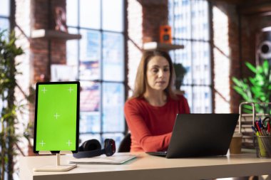 Merkez ofisteki Freelancer yeşil ekranın yanında online araştırma yapıyor ve internette sörf yapıyor, tele-iş için bir dizüstü bilgisayar kullanıyor ve dijital bir dünyada bağlı kalıyor. Sosyal medyaya bakılıyor.