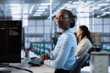 Veri merkezi altyapısını maksimum verimlilik ve boş zaman için yöneten ve optimize eden Afrikalı Amerikalı mühendis. Sunucu odasındaki kadın optimal sistem performansını sürdürüyor, yedekleme yapıyor