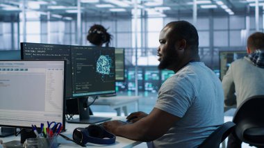 Mühendis kod yazıyor ve sunucu odasında farklı iş yükleri için hesaplama kaynakları sağlıyor. Veri merkezi ana bilgisayarlarını inceleyen adam bilgisayar, kamera A 'yı kullanıyor.