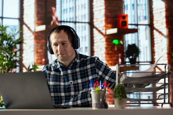 İç işleri çalışanı dizüstü bilgisayar kullanıyor, görüntülü arama yapıyor, iş arkadaşlarıyla sanal toplantıya katılıyor. Video konferans sırasında iş arkadaşlarıyla konuşan adam, kulaklık kullanıyor.