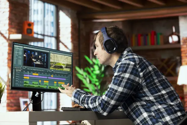 Video düzenleyici, video montaj yaparken kullanılacak anahtar çerçeveleri seçiyor, son teslim tarihinden önce bilgisayarda çalışıyor. Apartman ofisindeki film projesini düzenlemek için fareyi kullanan adam