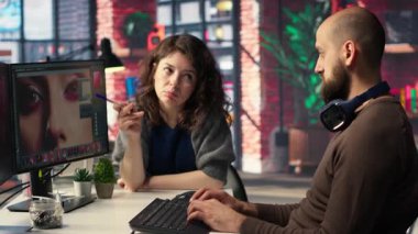 Erkek ve kadın yaratıcı ekip görüntü modelleri oluşturmak için yapay zekayı kullanıyor, dijital materyalleri geliştirmek ve kalite içeriği yaratmak için kurgu yazılımını çalıştırıyor. Fotoğraf rötuşlu yapay zeka asistanı. Kamera B.