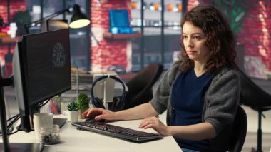 Yapay zeka bulutu için bilgisayar kullanan kadın bilişim geliştiricisi kendini öğrenme algoritmalarıyla hesaplıyor. Ajans sistem mühendisi AI ile birlikte masaüstünde çalışıyor. Kamera B.