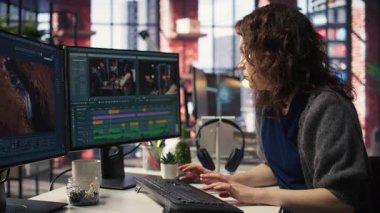 Kadın video yapımcısı bir film montaj projesi üzerinde çalışıyor, çift monitörlü birden fazla iş yapıyor. Kadın görüntüler editörü sinematik yaratıcılık sürecini başlatıyor, film kurgu endüstrisi. Kamera A.