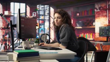 Dişi borsa simsarı çift monitörlerdeki borsa grafiklerini inceliyor, fiyatları paylaşmak için finansal büyümeyi takip ediyor. Ticaret arayüzü hisse alıp satmak için gerçek zamanlı veri sağlıyor. Kamera A.