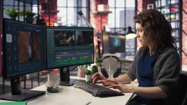 Yaratıcılık ajansında çift monitörlerle çalışan, video montajı yapan ve yaratıcı süreç için renk derecelendirme yapan bir kadın videograf. Çekim yapmak için prodüksiyon gönderin. Kamera A.
