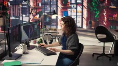 Kadın editör, yaratıcı ofisteki çift ekran masaüstündeki, bilgisayar kurulumundaki fotoğrafları rötuşluyor. Fotoğraf düzenleme üzerine odaklanmış dijital medya profesyoneli için ideal çalışma alanı. Kamera A.