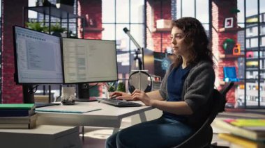 Ofisteki genç kadın bilgisayar ekranında UI 'ye bakıyor ve yazılımda test ve uygulama için ikili kod kullanıyor. Bilgisayar bilimi için kodlama uygulaması. Kamera A.