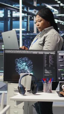 Sistem sağlığını optimize etmek için yapay zeka görüşlerini kullanan neşeli sunucu merkezi teknisyeninin dikey video portresi. Neşeli veri merkezi bilişim uzmanı düğüm ağacı araçları kullanarak dişli sorunlarını analiz ediyor, kamera A